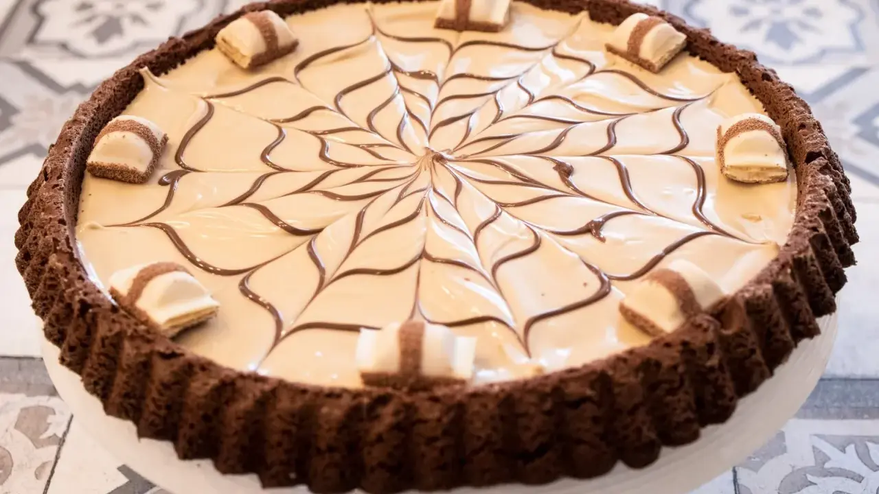Torta Kinder Bueno con decorazione a ragnatela di cioccolato e pezzi di wafer.