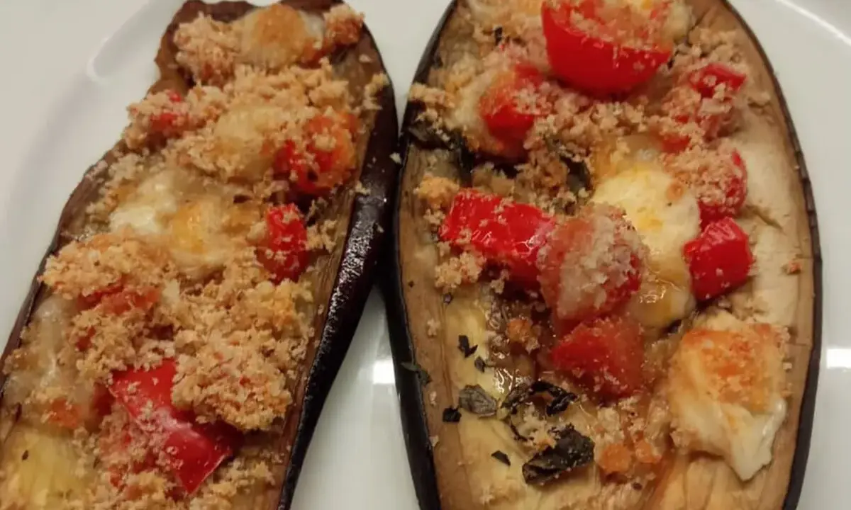 Melanzane ripiene al forno, con pomodorini, formaggio filante e pangrattato croccante. Un'ottima crema di melanzane.