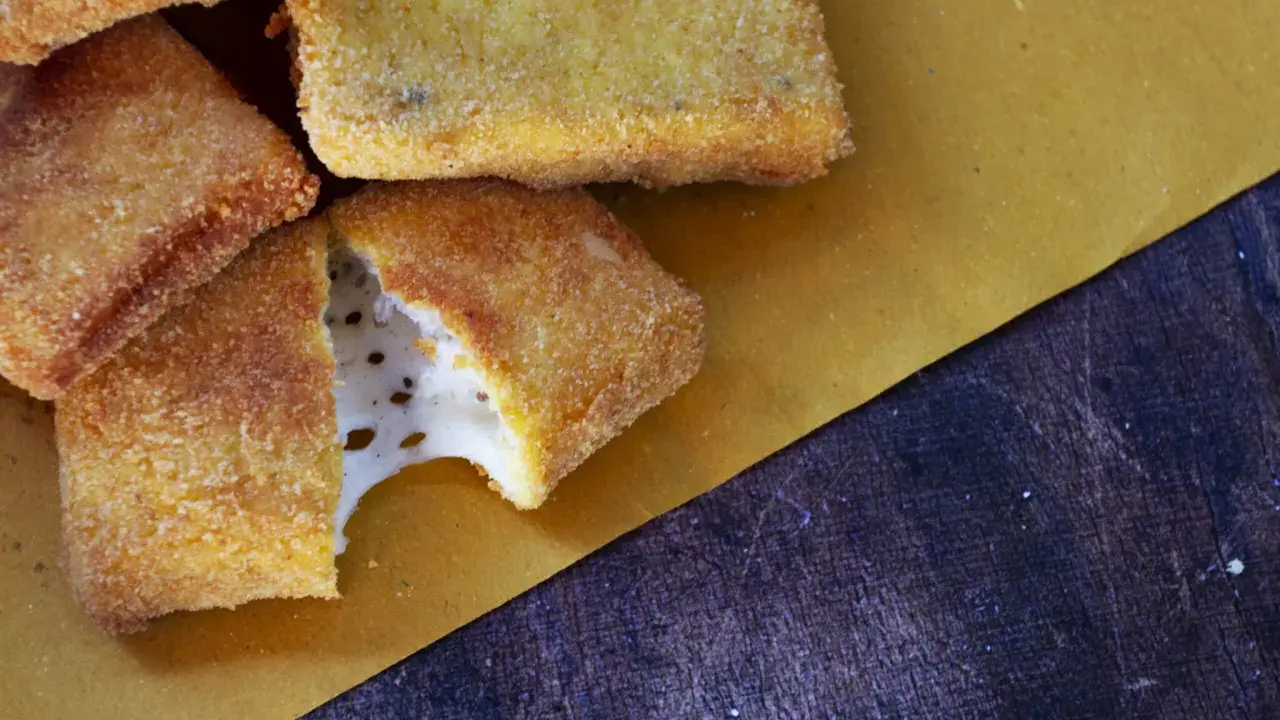 Mozzarella in carrozza dorata e croccante, con il formaggio filante che fuoriesce da uno spicchio.
