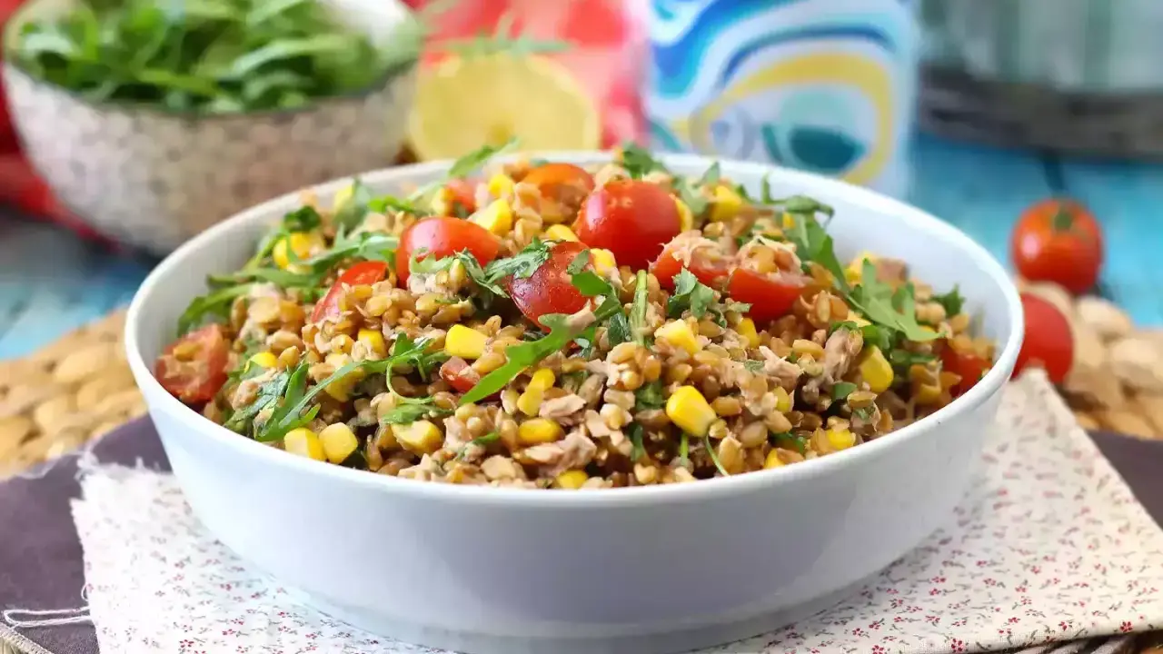 Una gustosa insalata di farro estiva con pomodorini, mais e rucola, perfetta per un pasto leggero e nutriente.