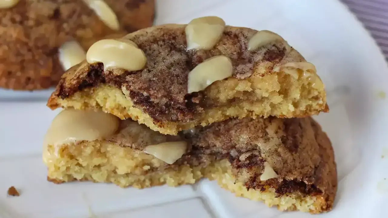 Biscotti alla cannella con gocce di cioccolato e mandorle, uno spezzato mostra l'interno morbido e profumato.