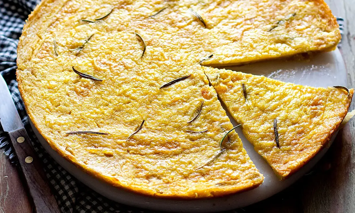 Farinata di ceci dorata e profumata al rosmarino, appena sfornata e tagliata a spicchi, pronta per essere gustata.