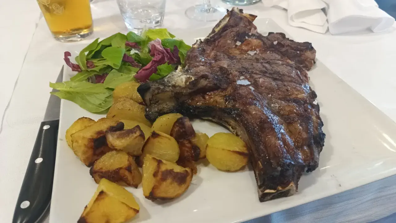 Costata di manzo succulenta con patate arrosto e insalata fresca, un piatto da re.