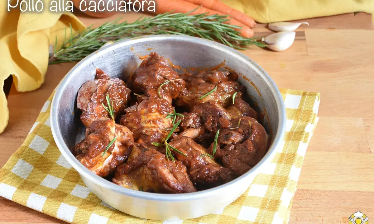 Succulento pollo alla cacciatora in padella, con rosmarino fresco e contorni di carote e aglio.