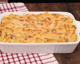 Un invitante pasta al forno bianca, con maccheroni dorati, piselli e carne macinata, gratinata al punto giusto.