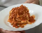 Un piatto di tagliatelle al ragù, un classico della cucina italiana, servito su un piatto bianco.