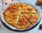 Una deliziosa torta di patate dorata e croccante, guarnita con rosmarino fresco, pronta per essere gustata.