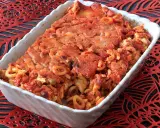 Un invitante piatto di anelletti al forno, con pasta corta condita con sugo rosso e formaggio gratinato, pronto per essere gustato.