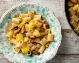 Un piatto di pasta patate e cozze, un classico della cucina italiana, servito in una ciotola decorata.