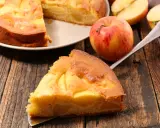 Una fetta di torta di mele senza burro, dorata e soffice, con mele a vista. Accanto, una mela rossa e gialla e altre fette.