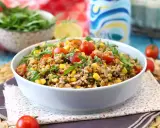 Una gustosa insalata di farro estiva con pomodorini, mais e rucola, perfetta per un pasto leggero e nutriente.