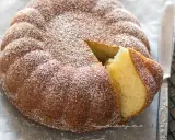 Torta 7 vasetti soffice e dorata, spolverata di zucchero a velo. Una fetta è stata tagliata, rivelando l'interno profumato.