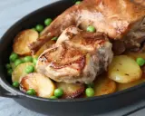 Coniglio arrosto in padella con patate e piselli, un piatto succulento e invitante.