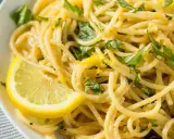Spaghetti al limone cremosi, guarniti con scorza di limone e basilico fresco. Un piatto invitante e profumato.