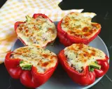 Quattro peperoni ripieni in friggitrice ad aria, con formaggio fuso e spezie, pronti per essere gustati.