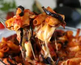 Un primo piatto fumante di pasta alla norma, con melanzane fritte, pomodoro e tanto formaggio filante che si allunga.