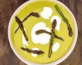 Crema di asparagi vellutata, guarnita con asparagi croccanti e un tocco di panna.