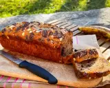 Delizioso banana bread vegano con gocce di cioccolato e mandorle, pronto per essere gustato all'aperto.