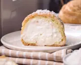 Bignè ripieno di crema soffice, cosparso di zucchero a velo che ricorda un fiocco di neve.