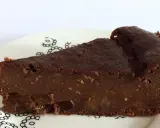 Una fetta di torta di pane al cioccolato, umida e ricca, con pezzi di frutta secca. La torta di pane ricetta della nonna, servita su un piatto bianco con decorazioni nere.