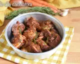 Succulento pollo alla cacciatora in padella, con rosmarino fresco e contorni di carote e aglio.