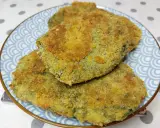 Tre spinacine fatte in casa, dorate e croccanti, servite su un piatto blu con decorazioni a onde.