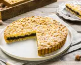 Sbriciolata alla Nutella con tante nocciole croccanti, un dolce invitante su un piatto bianco, pronto per essere gustato.