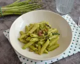 Penne cremose con asparagi freschi e cubetti di speck croccante, un piatto primaverile gustoso.