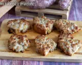 Sei crostini salsiccia e stracchino dorati e filanti, pronti per essere gustati.