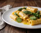 Rigatoni cremosi con asparagi freschi, un'interpretazione primaverile della carbonara di asparagi, conditi con pepe nero.