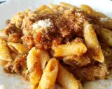 Penne al ragù di cinghiale, un piatto ricco e saporito, condito con abbondante sugo e una spolverata di parmigiano.