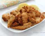 Straccetti di pollo in friggitrice ad aria, croccanti e dorati, serviti con spicchi di limone. Perfetti per un pasto leggero e gustoso.