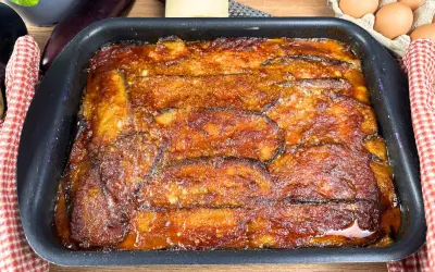 Parmigiana di melanzane appena sfornata, dorata e succulenta, pronta per essere gustata.