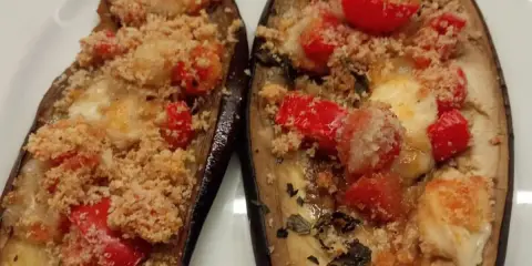 Melanzane ripiene al forno, con pomodorini, formaggio filante e pangrattato croccante. Un'ottima crema di melanzane.