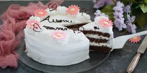Torta decorata con fiori rosa e scritte in cioccolato, perfetta per la torta festa della mamma. Un dolce per celebrare con amore.