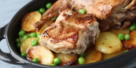 Coniglio arrosto in padella con patate e piselli, un piatto succulento e invitante.