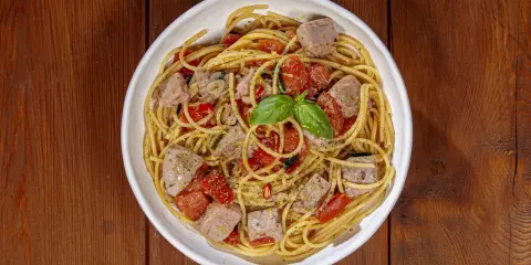 Spaghetti al tonno, un classico profumato, come la spaghetti al tonno ricetta della nonna, con pomodorini e basilico fresco.