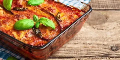 Parmigiana di melanzane in friggitrice ad aria, dorata e profumata, guarnita con basilico fresco. Un classico rivisitato per un risultato leggero e gustoso.