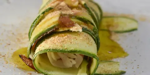 Delizioso rotolo di zucchine, avvolto con cura e cosparso di pangrattato e olio d'oliva. Un piatto leggero e gustoso.