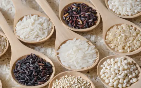 Cucchiaiate di riso per risotti: bianco, nero e integrale. Una selezione di chicchi pronti per creare piatti cremosi e gustosi.