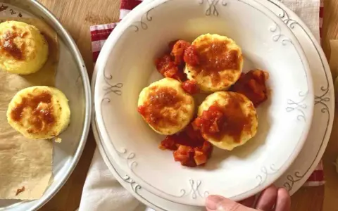 Gnocchi alla romana dorati e gustosi, serviti con un sugo di pomodoro saporito.