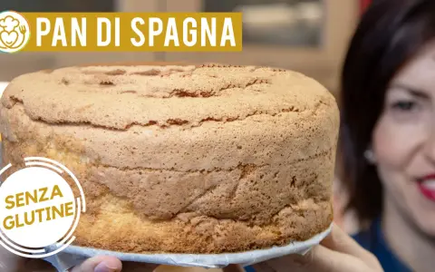Un soffice pan di spagna senza glutine, pronto per essere farcito. La donna sorride sullo sfondo.