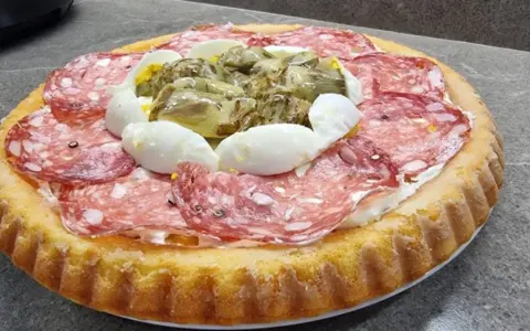Crostata morbida salata con salame, uova sode e carciofini sott'olio, un'idea gustosa per un aperitivo o un antipasto.