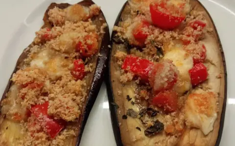 Melanzane ripiene al forno, con pomodorini, formaggio filante e pangrattato croccante. Un'ottima crema di melanzane.