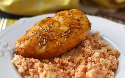 Petto di pollo in friggitrice ad aria, dorato e aromatico, servito su un letto di couscous.