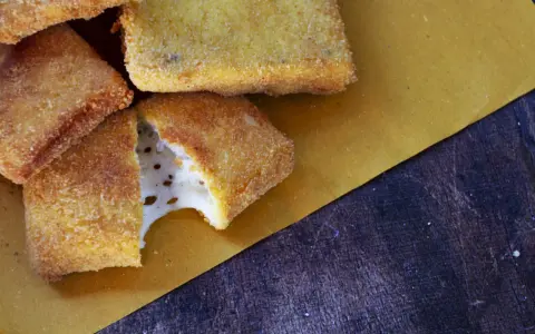 Mozzarella in carrozza dorata e croccante, con il formaggio filante che fuoriesce da uno spicchio.