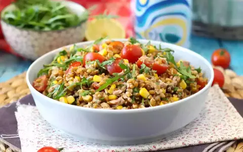 Una gustosa insalata di farro estiva con pomodorini, mais e rucola, perfetta per un pasto leggero e nutriente.