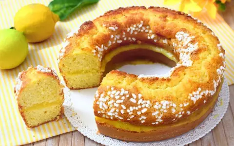 Torta al limone morbidissima e profumatissima benedetta, con ripieno cremoso e decorata con perle di zucchero.