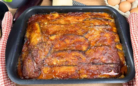 Parmigiana di melanzane appena sfornata, dorata e succulenta, pronta per essere gustata.