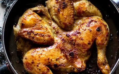 Pollo alla diavola succulento e dorato, cotto in padella con spezie piccanti.
